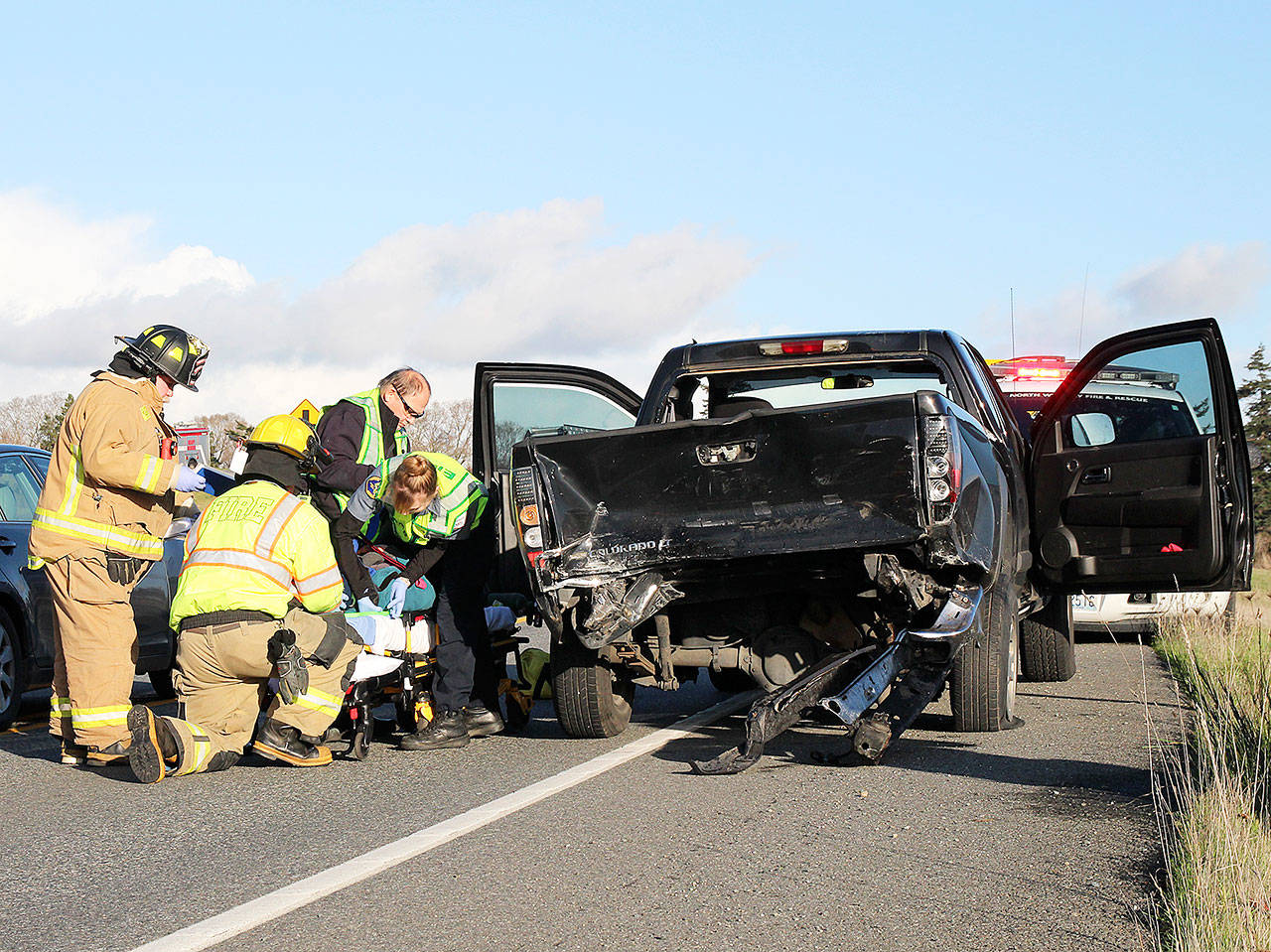 First responders help a woman who was driving a pick-up involved in an accident Monday afternoon. She and the passenger in the other vehicle were both transported to WhidbeyHealth Medical Center for unknown injuries. Photo by Laura Guido/Whidbey News-Times