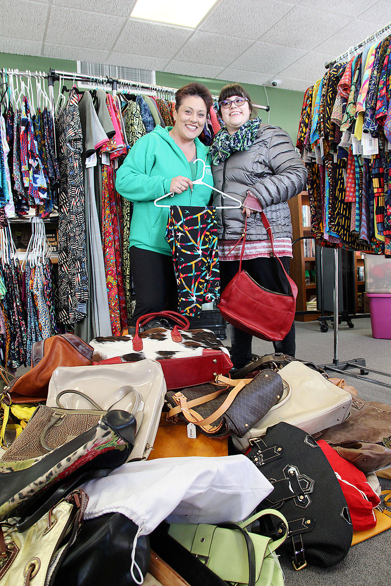 Garage of Blessings founder Kristiina Miller and her daughter Chloe Miller stand surrounded by recently donated purses and clothing. The items will be given away at a special event on Jan. 19. Photo by Laura Guido/Whidbey News-Times