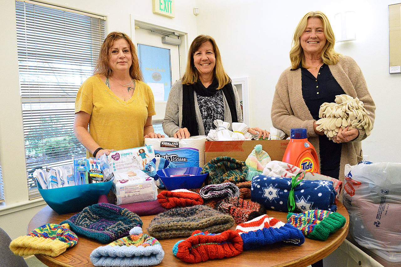 Island County Human Services staff members Wendy Beagle, Kathryn Clancy and Joanne Pelant show donated items the agency has received. They work with a number of disaffected people in the community and give the items away to those that need them. Photo by Laura Guido/Whidbey News Group