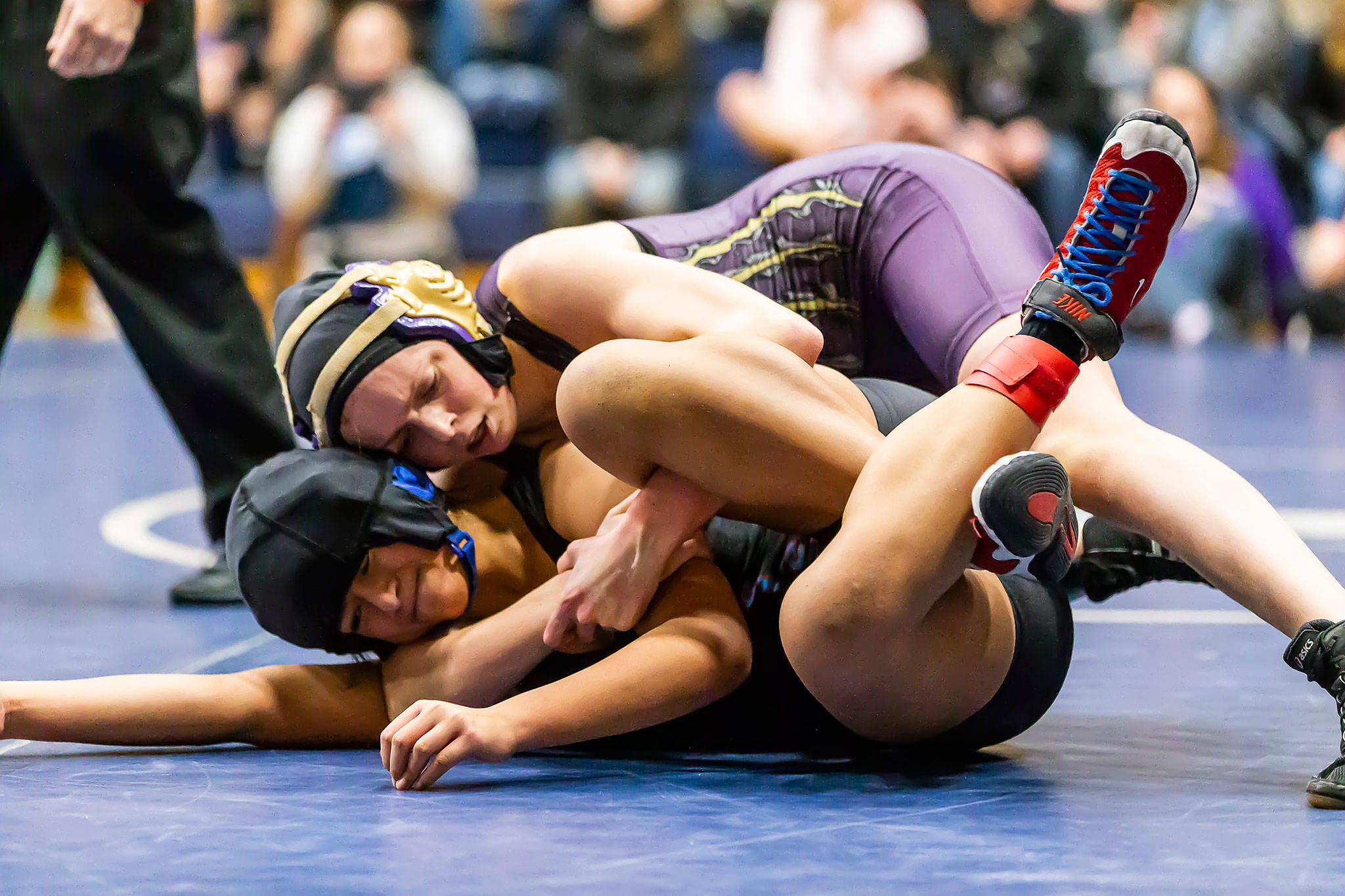 Oak Harbor’s Ella Erikson, top, competes in the Arlington tournament Saturday. Erikson finished second in the 115-pound class. (Photo by John Fisken)