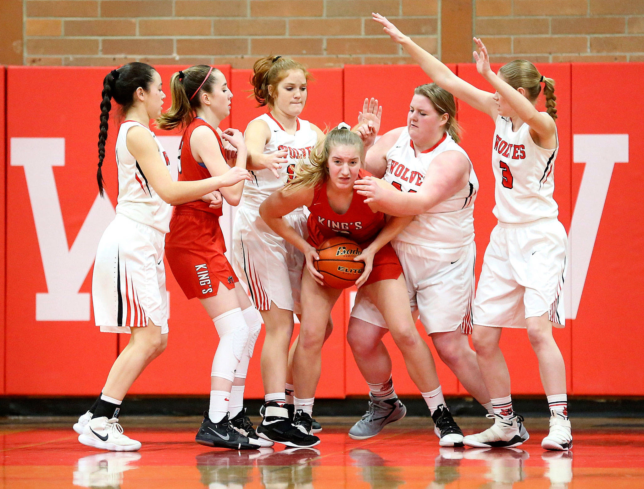 A King’s player draws a crowd of Coupeville defenders. From the left for the Wolves are Scout Smith, Ema Smith, Nicole Laxton and Chelsea Prescott.(Photo by John Fisken)