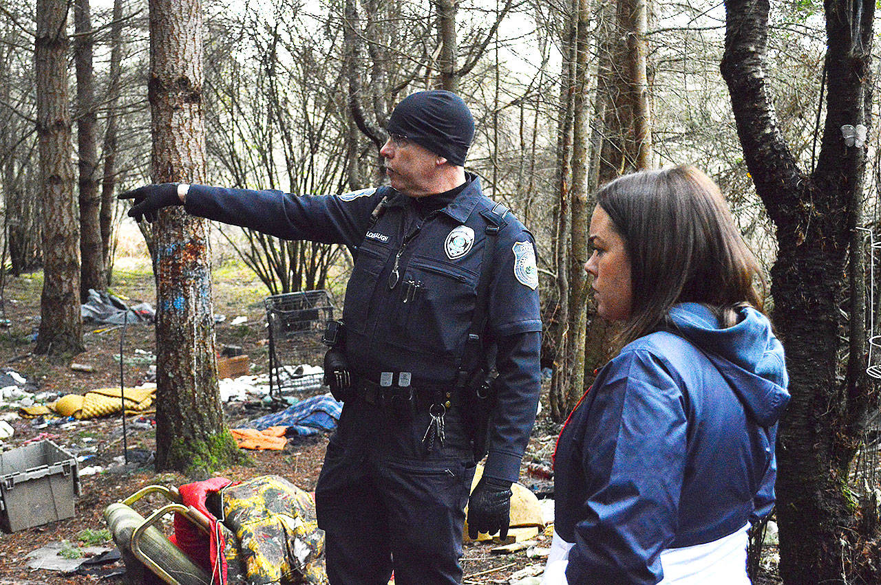 Officer Mel Lolmaugh, Oak Harbor Police Department, points out to Cynthia Besaw, county veterans resource coordinator, areas homeless individuals have been known to occupy in an area called The Pit off Goldie Road. He accompanied Besaw and other volunteers to the area during the annual Point in Time homeless population count in January. Photo by Laura Guido/Whidbey News-Times