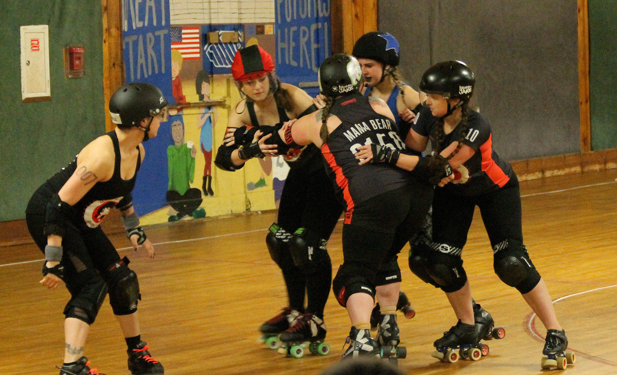 Tina Bond, Jennifer Garlington, Misty Awbrey-Ford and Nic O’Neill set up a roadblock for the Bunnies’ jammer. (Photo by Jim Waller/Whidbey News-Times)