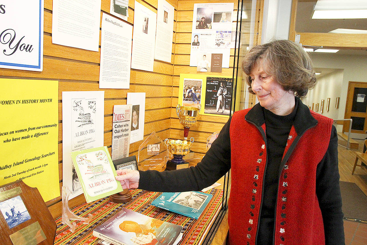 Pat Gardner, member of Whidbey Island Genealogy Searchers, holds her contribution to the club’s women’s history display at Oak Harbor Library. Photo by Laura Guido/Whidbey News-Times