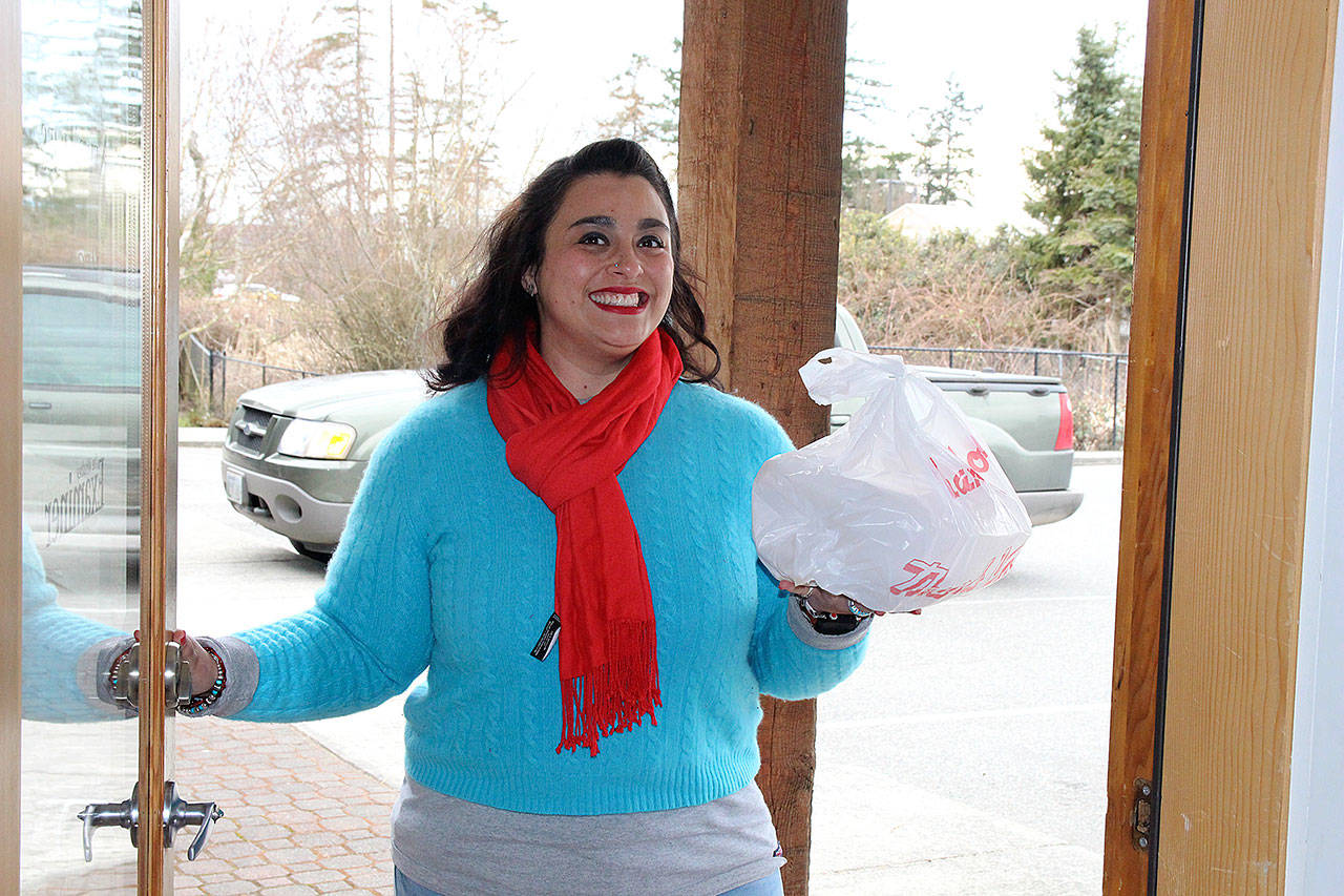 Crystal Aguilar, owner and founder of Whidbey Waiter, makes a delivery at a Coupeville office. Her business also delivers groceries, flowers, takes trash to the dump and makes Costco runs for its customers.Photo by Laura Guido/Whidbey News Group