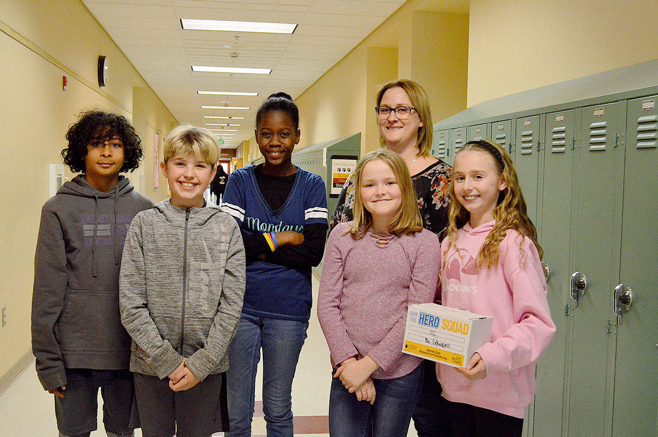 From left, fifth graders Riley Jackson, Grady Anderson, Suki Wardea, Elizabeth Hauter, and Scarlett Nations stand with their leadership teacher Amber Worman at Oak Harbor Intermediate School. The group led an effort to raise more than $8,000 for cancer research to be donated in the name of a staff member. Photo by Laura Guido/Whidbey News-Times