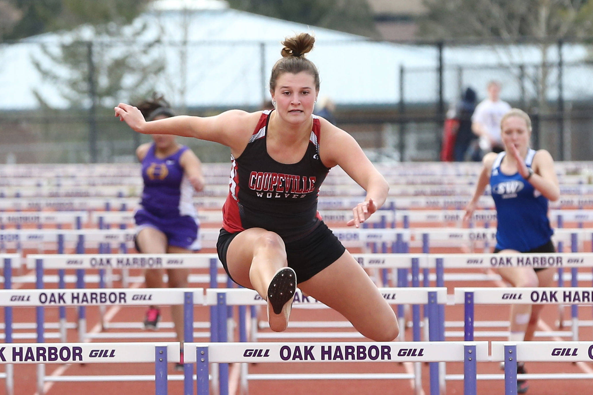 Coupeville’s Lindsey Roberts races to first place in the 100 hurdles. She also took first in the 200 at the Island Jamboree Thursday. (Photo by John Fisken)