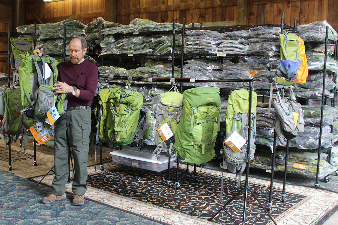 Rich Murphy uses an old barn as a warehouse for a line of backpacks called Aarn that are designed in New Zealand and sold worldwide. Murphy and his wife, Genie, are the new North American distributers for the backpacks that emphasis balance and reducing strain while hiking. (Photo by Patricia Guthrie/Whidbey News Group)                                Rich Murphy shows tandem packs that can attach to backpacks and be worn in front to help with balance. (Photos by Patricia Guthrie/Whidbey News Group)                                The backpacking equipment company called Aarn began when New Zealander founders Aarn Tate and Devi Benson began designing outdoor products to be more “body-comfortable.” The material is extremely tough but light and durable. The store’s balance bags run around $70 to $150 and the full backpacks $200 to $400.