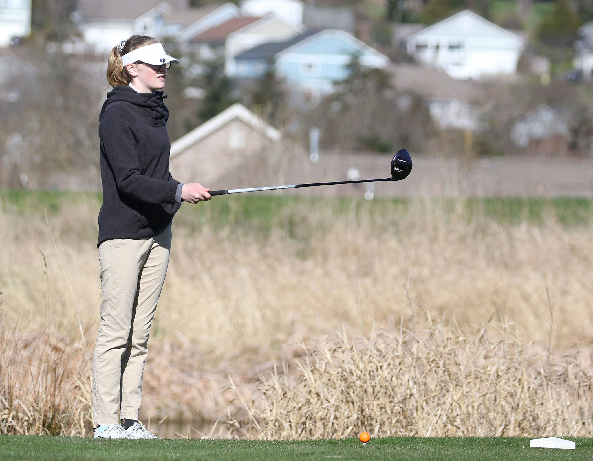 Sara Rhodes lines up a tee shot in Oak Harbor’s match with Everett Tuesday.(Photo by John Fisken)