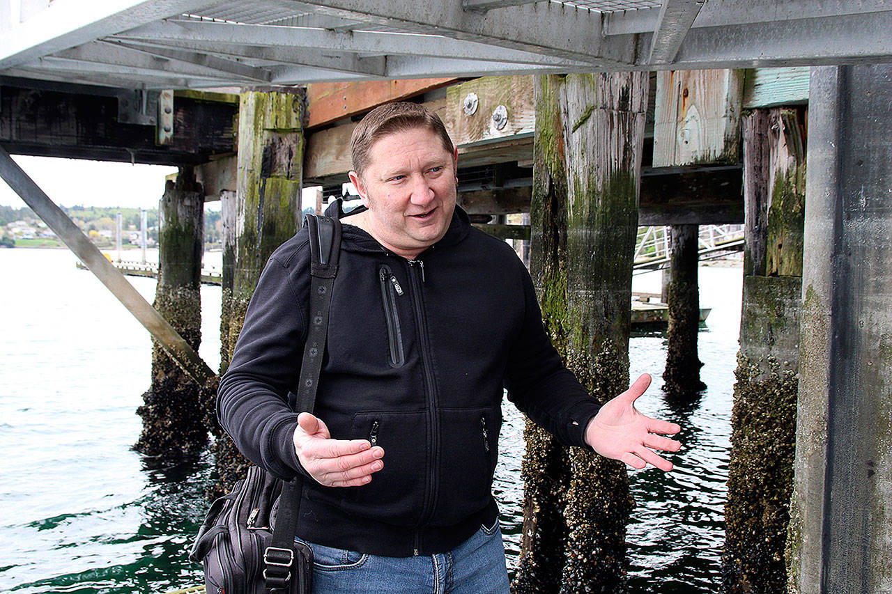 Port Executive Director Chris Michalopoulos speaks about the state of the Coupeville Wharf. Behind him are piles that have been severely eaten away by “marine boring organisms” over the years and need replacing. (Photos by Laura Guido/Whidbey News-Times)