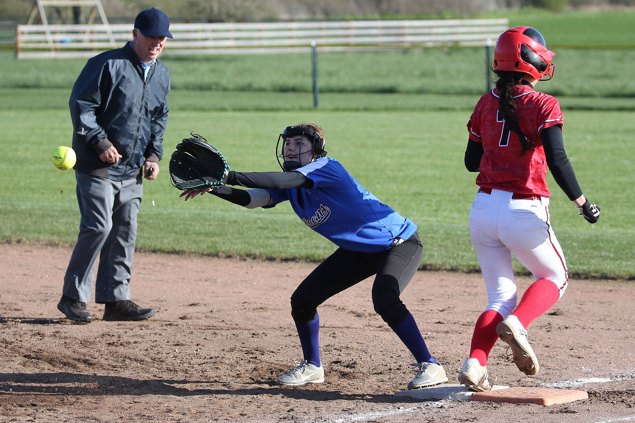 Coupeville’s Scout Smith (7) reaches first base before South Whidbey’s Melody Wilkie makes the catch as umpire Randy James looks on.(Photo by John Fisken)