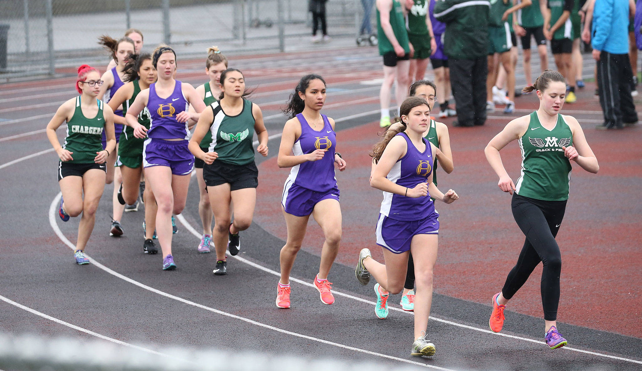 Oak Harbor’s Evelyn Osburn, second from right, and Stephanie Mayer run with the leaders in the 1,600 Thursday. (Photo by John Fisken)