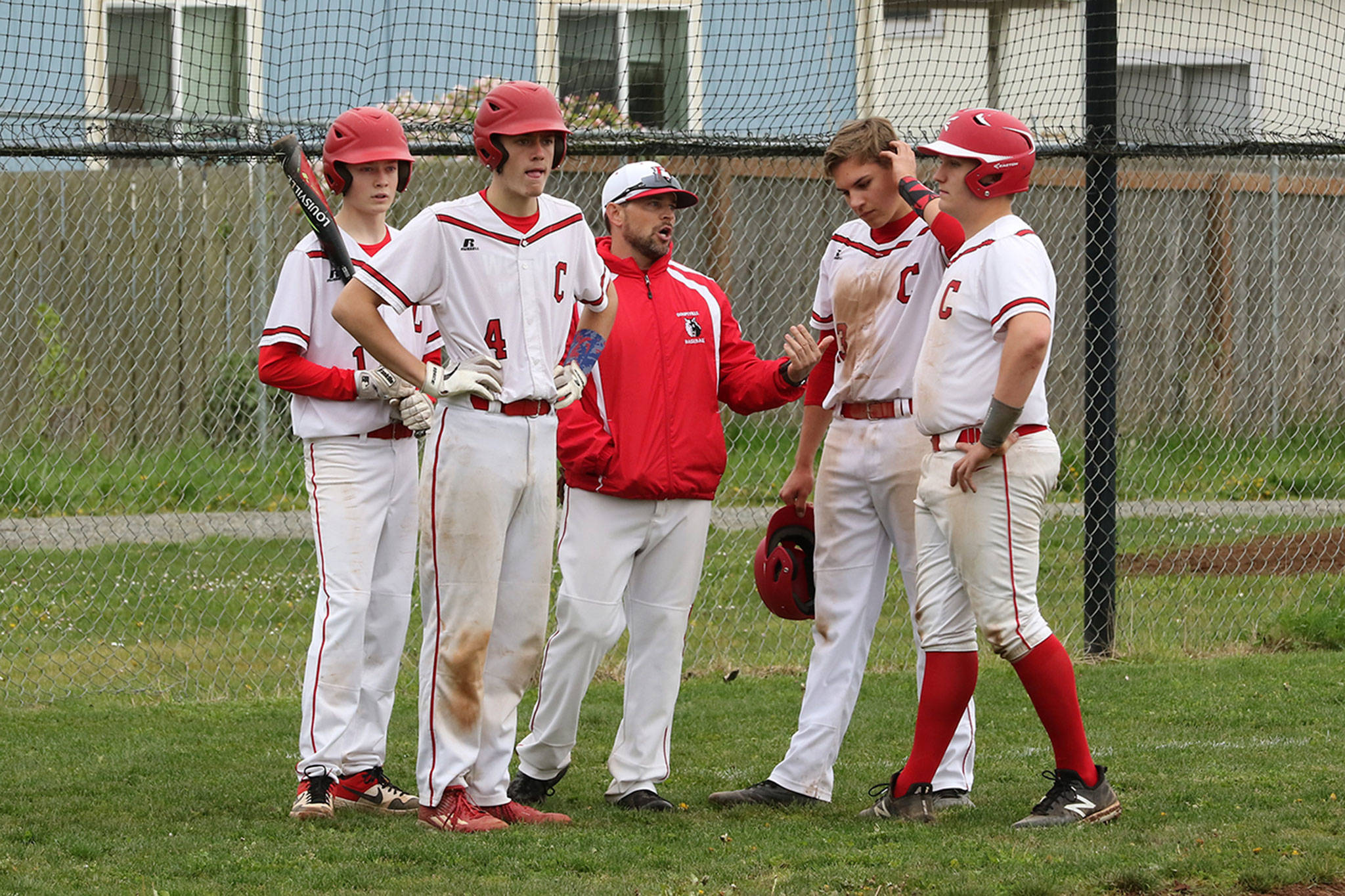 Coupeville coach Chris Smith, center, confers with his offense during a Granite Falls time out. From the left are Daniel Olson, Gavin Knoblich, Jake Pease Dane Lucero.(Photo by John Fisken)