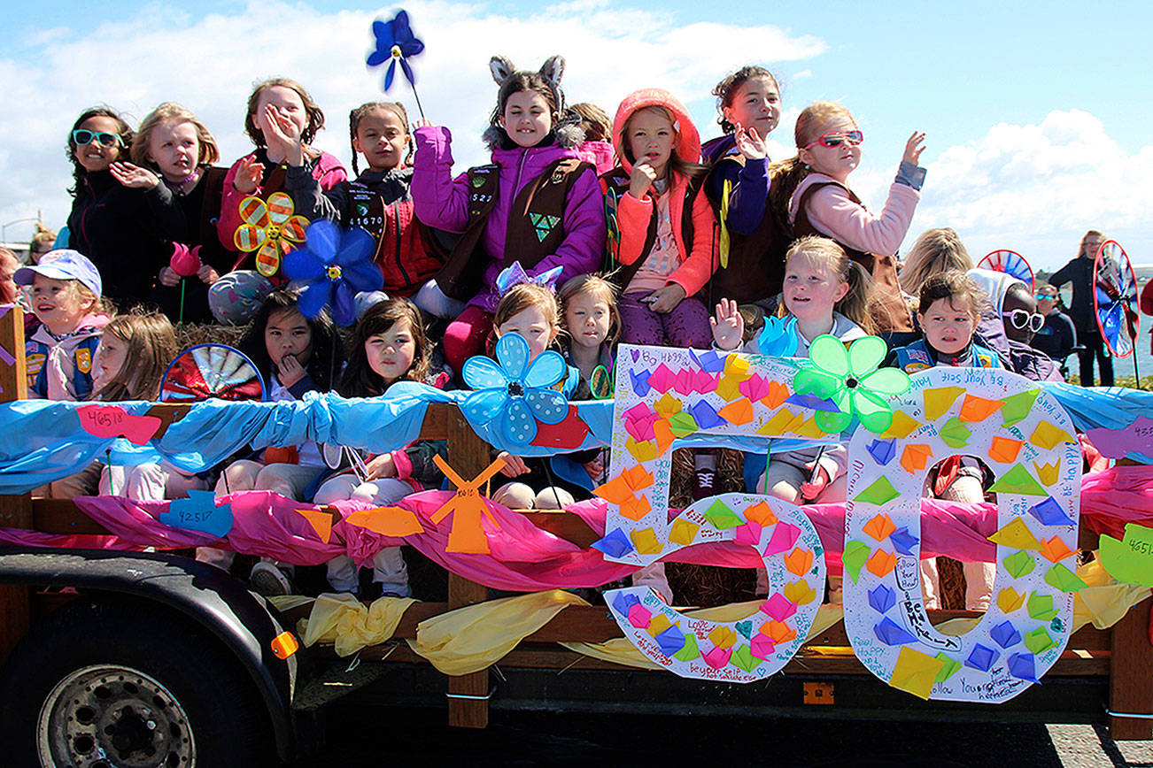 The Girl Scouts of Western Washington wave to the crowd at the Holland Happening parade, now in its 50th year.