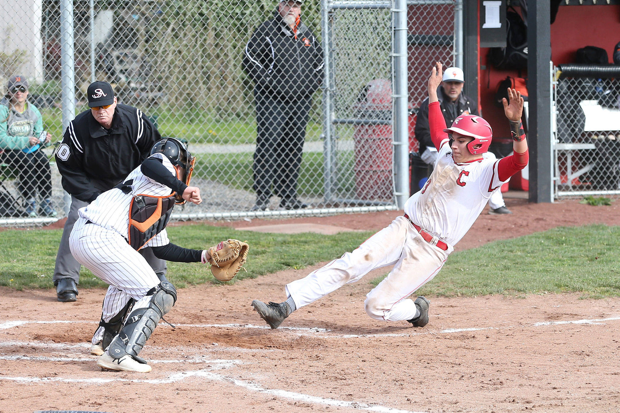 Coupeville’s Jake Pease sides under the tag of Granite Falls’ Cameron Tappe to score a first-inning run for the Wolves.(Photo by John Fisken)