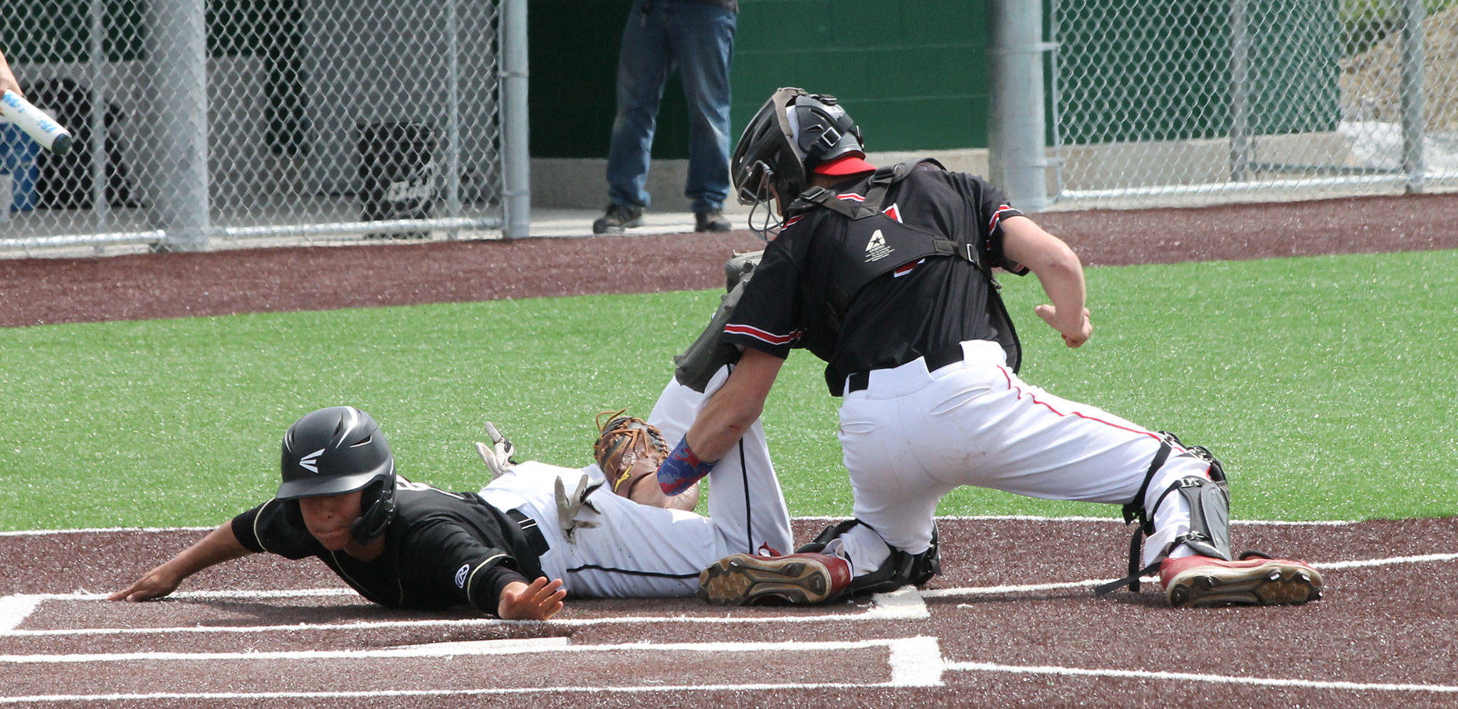 Coupeville catcher Gavin Knoblich appears to tag out Meridian’s Arturo Madrigal. Madrigal, however, was called safe on the play in the Trojans’ win.(Photo by Jim Waller/Whidbey News-Times)