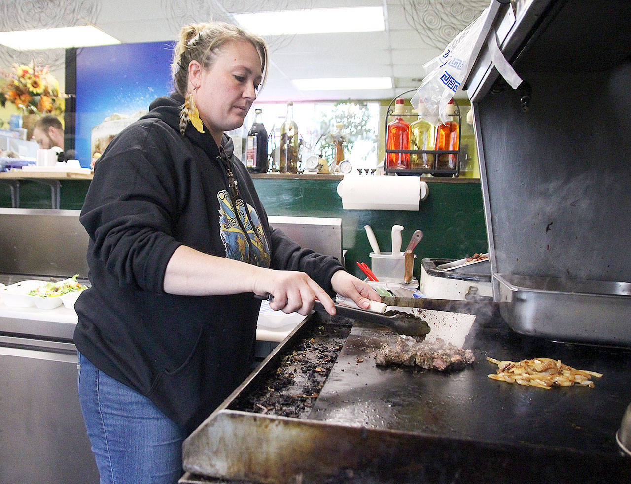 Jessie Abrahamson girlls meat at A.B.’s Hillbilly Gyros. She recently took over Nadya’s Greek Cuisine, where she had worked as a teenager. Photo by Laura Guido/Whidbey News-Times