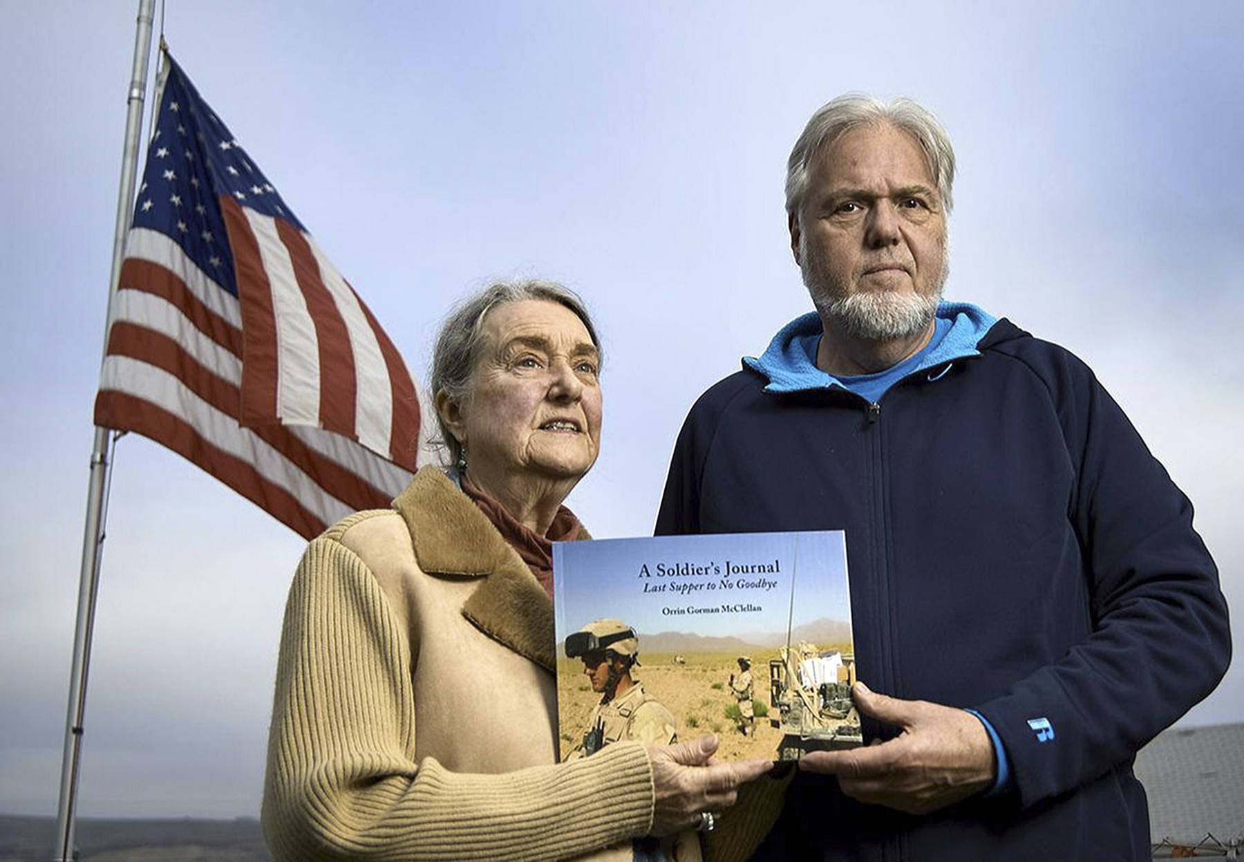 Photo submitted                                Judith Gorman and Perry McClellan hold the book compiled from the personal writings of their son Orrin, who killed himself after struggling with post-traumatic stress disorder and other injuries sustained during 2005-2006 Afghanistan combat. The former Langley couple have moved to Soap Lake where they always keep their flag at half-staff in front of their home.
