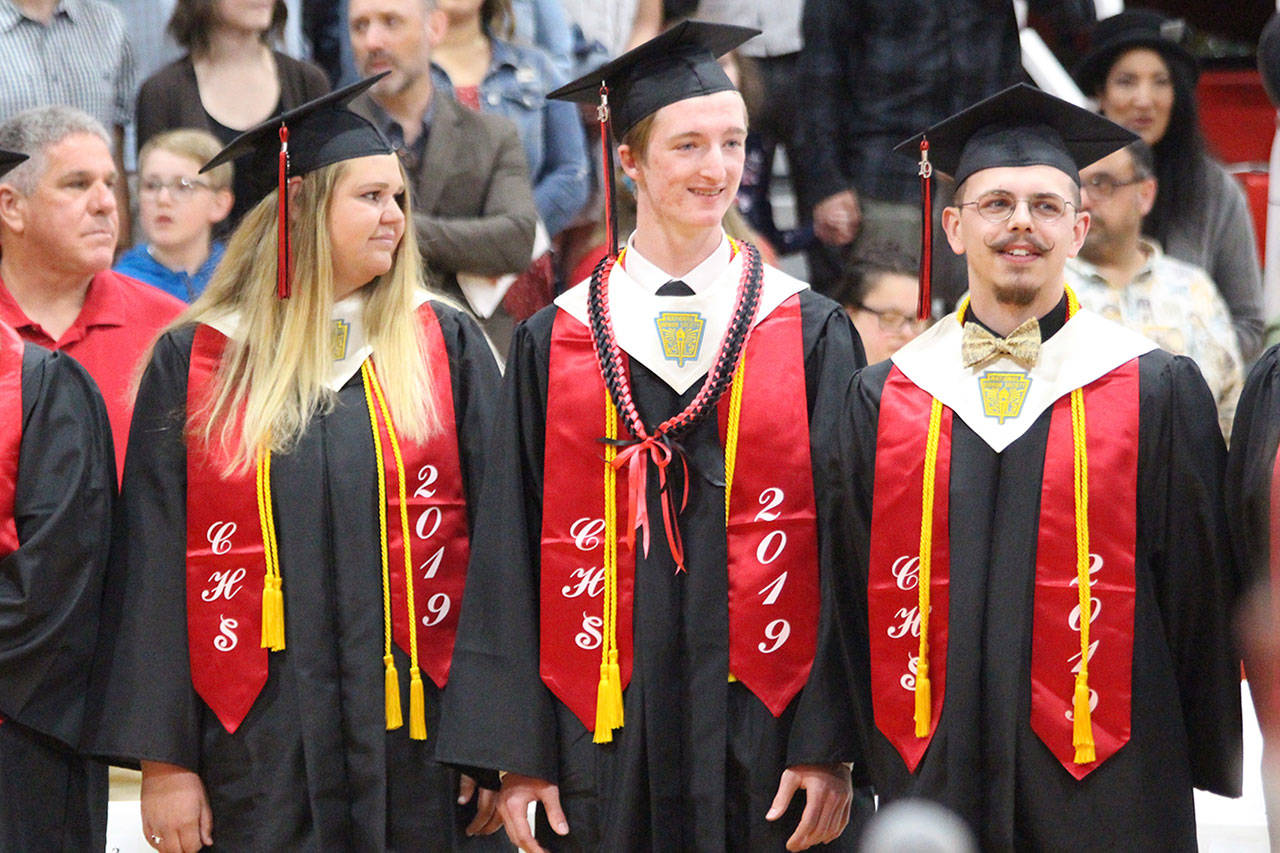 Veronica Crownover, Jakobi Baumann and Nikolai Lyngra stand at the graduation ceremony as the class is welcomed. Photo by Maria Matson/Whidbey News-Times