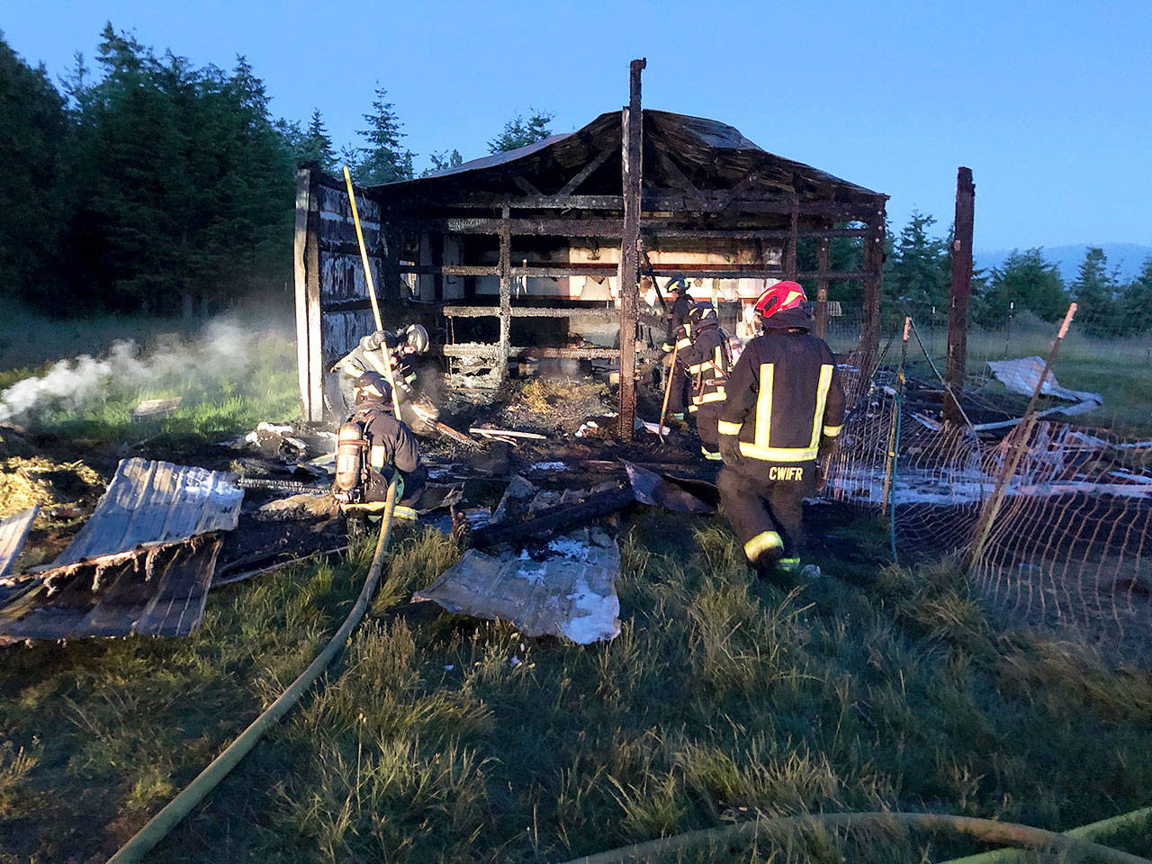 Central Whidbey Island Fire and Rescue firefighters work to extinguish a fire Tuesday morning at a barn in Greenbank. Photo provided