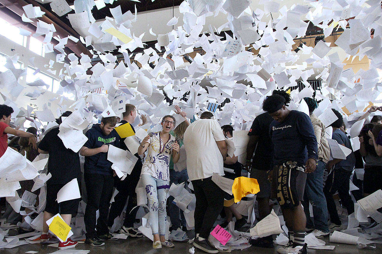 AJ Diamond, center, laughs as she and her classmates at Oak Harbor High School are enveloped in old assignments, notes, essays and tests during the traditional paper toss Wednesday. Photo by Laura Guido/Whidbey News Times