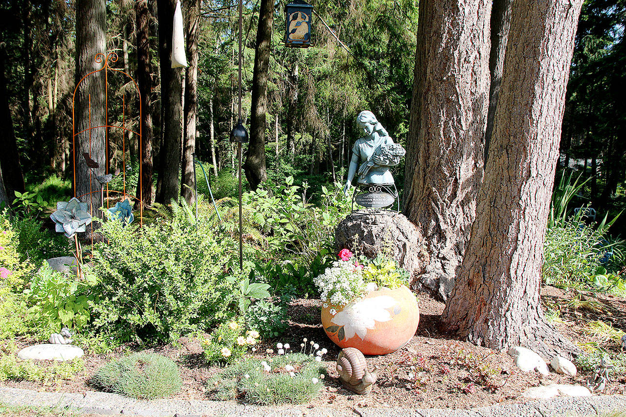 The Medburys’ garden is accented with statues, glass art and thrift shop finds.