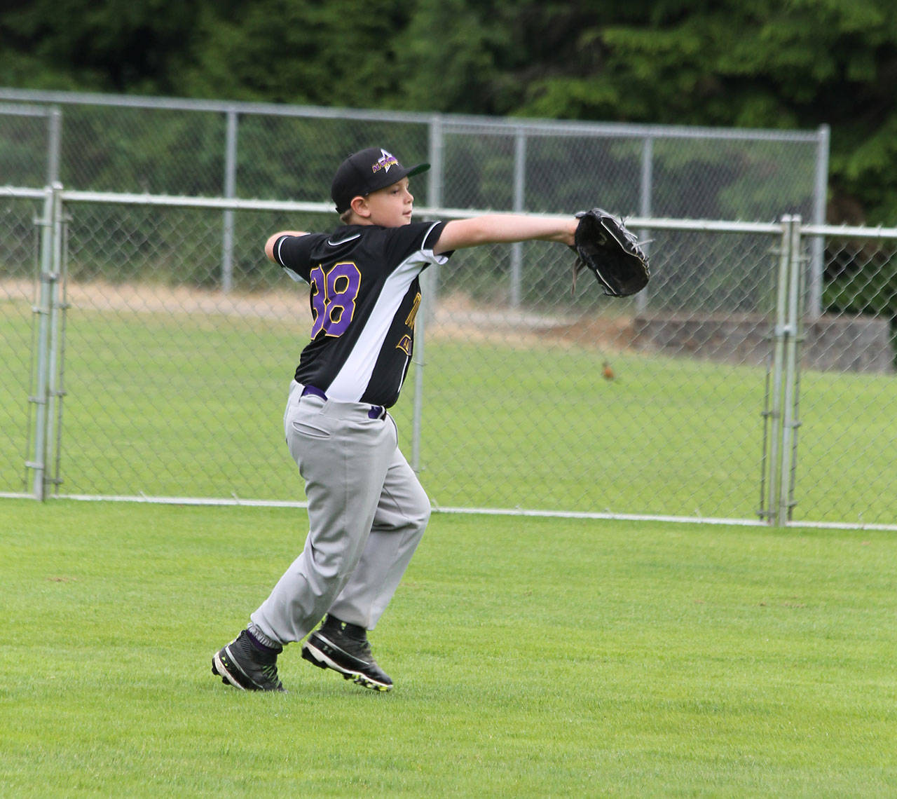 Left fielder Brayden McGhee tosses the ball back to the infield in Sunday’s game. (Photo by Jim Waller/Whidbey News-Times)