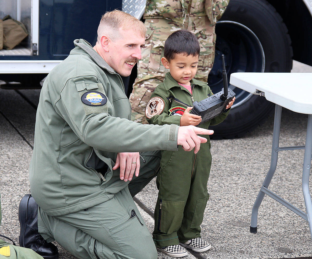 Photo by Laura Guido/Whidbey News-Times                                Andrew Bennett helps his 3-year-old son Kai Bennett to operate an explosive ordnance disposal robot Satuday at the Navy open house.