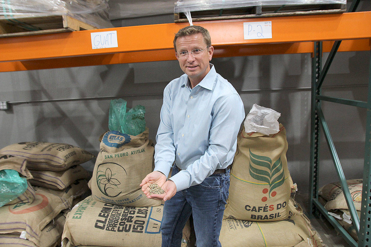 Whidbey Coffee owner Dan Ollis holds a handful of green coffee beans that will be roasted at the company’s facility in Mukilteo. (Photos by Jessie Stensland / Whidbey News-Times)