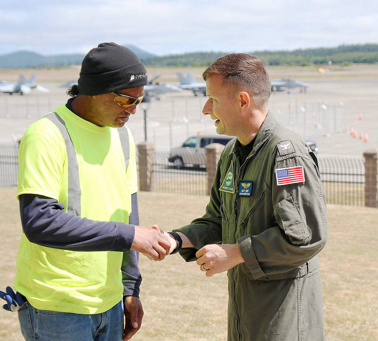Pulu accepts a coin of recognition from Naval Air Station Whidbey Island base commander Capt. Matt Arny.