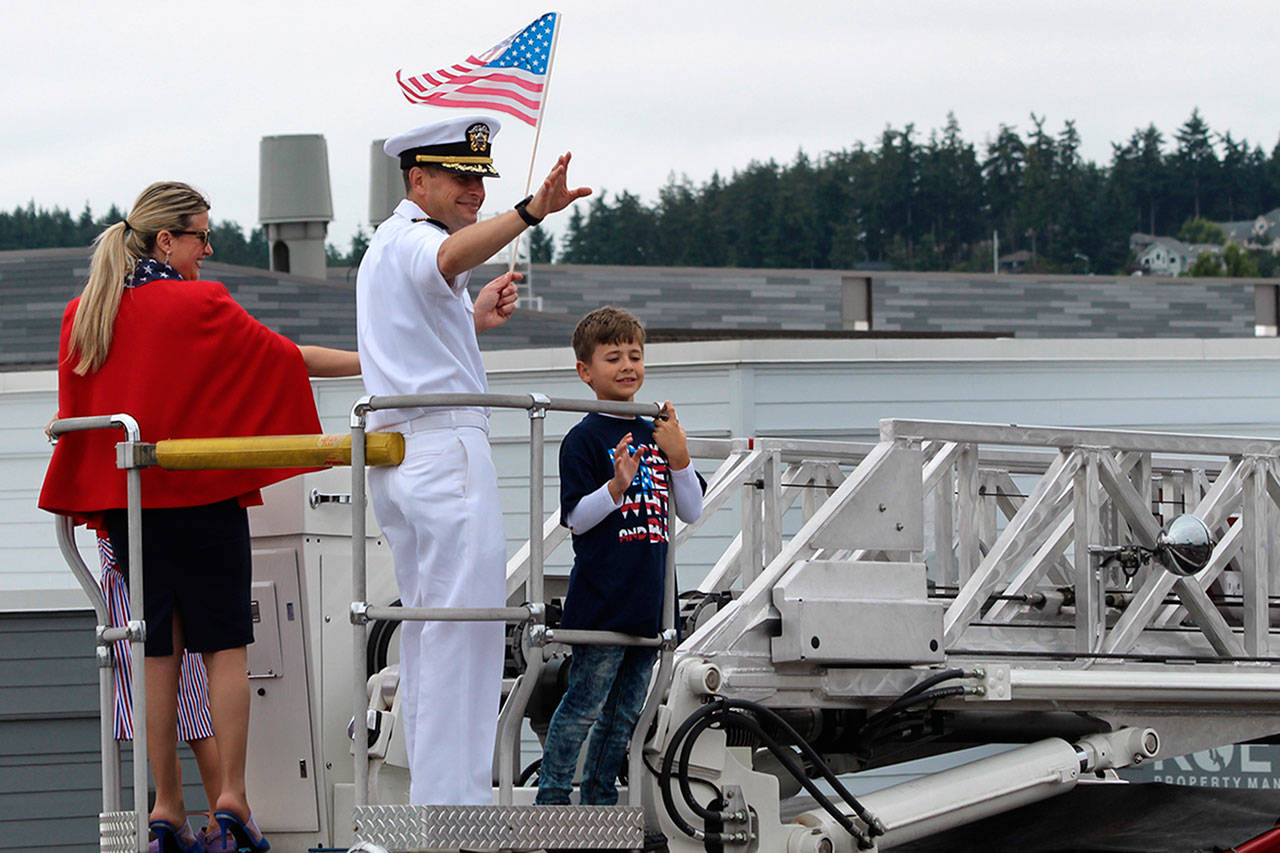 Capt. Matthew Arny, commanding officer for Naval Air Station Whidbey Island, and his family wave to the crowd.