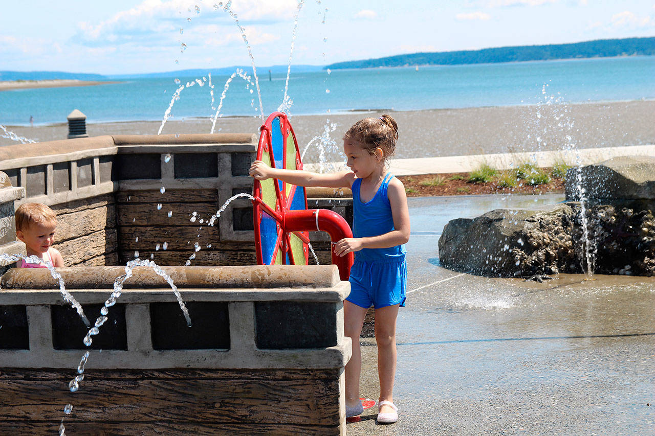 Sophia Valle, 5, rotates a watery wheel at Shipwreck Shores. Valle said she liked the new park because it has a broken ship, rocks and more.                                (Photos by Maria Matson/Whidbey News-Times)