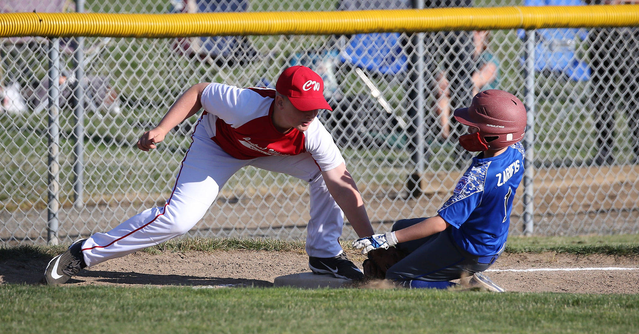 Third baseman Camden Glover tags out South Whidbey’s Alexander Zarifis trying to steal third base.(Photo by John Fisken)