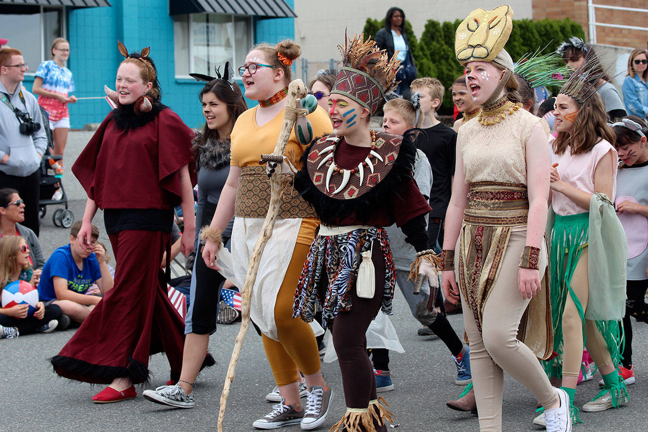 Cast members in their costumes walked in Oak Harbor’s Fouth of July parade with the Whidbey Playhouse float. Front row left to right: Brynn Schmid as Pumbaa, Alora Van Auken as a lioness, Jessica Turner as Rafiki and Elizabeth Löf as Sarifina. (Photo by Maria Matson/Whidbey News-Times)
