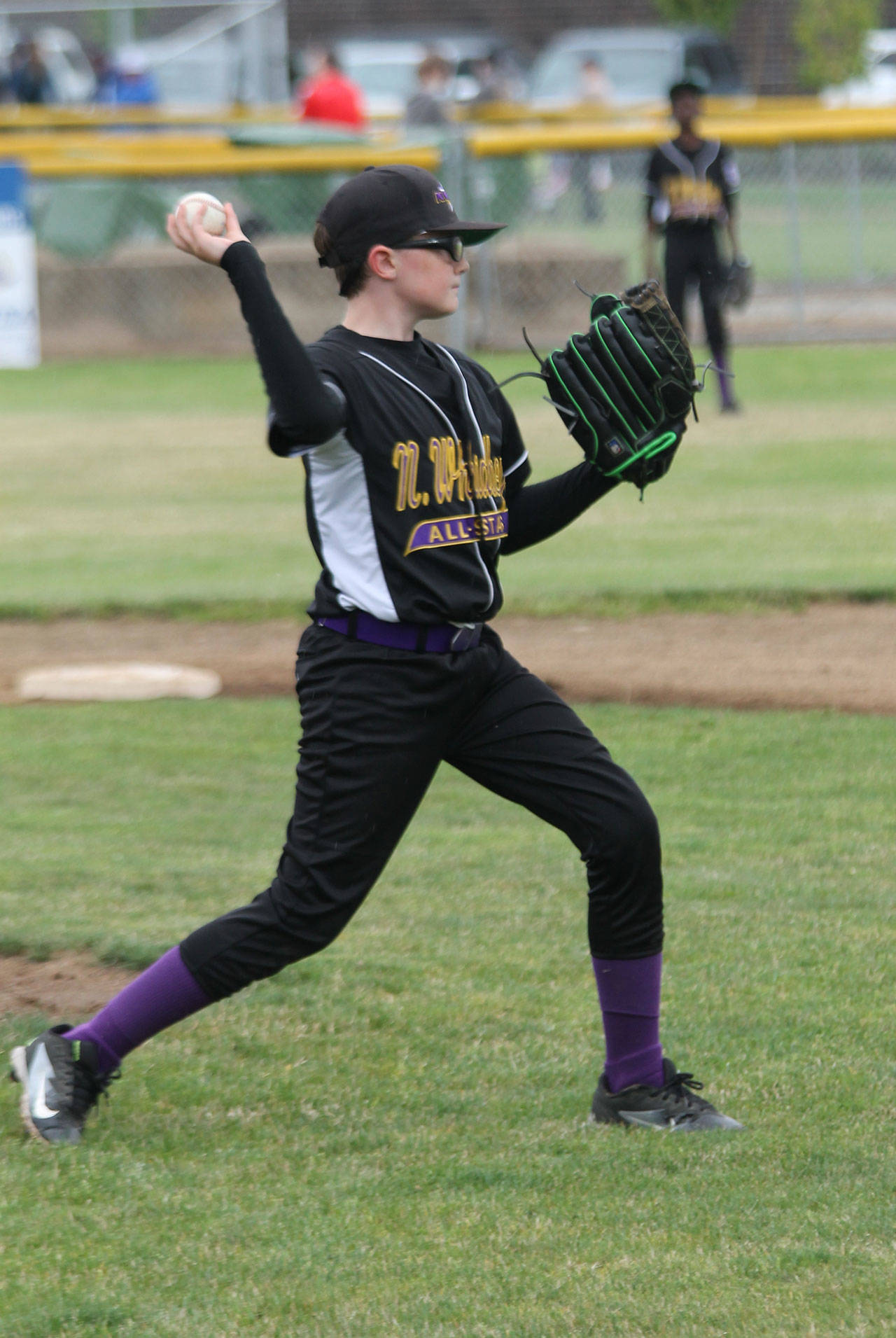 After fielding a comebacker, pitcher Coop Cooper tosses to first for an out.(Photo by Jim Waller/Whidbey News-Times)