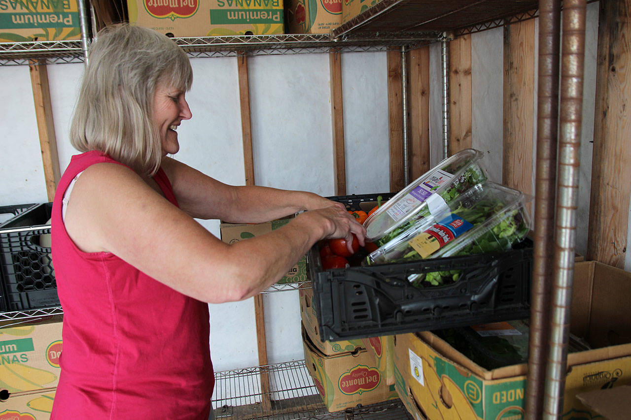 Executive Director Jean Wieman sorts through fresh produce. (Photo by Maria Matson/Whidbey News-Times)