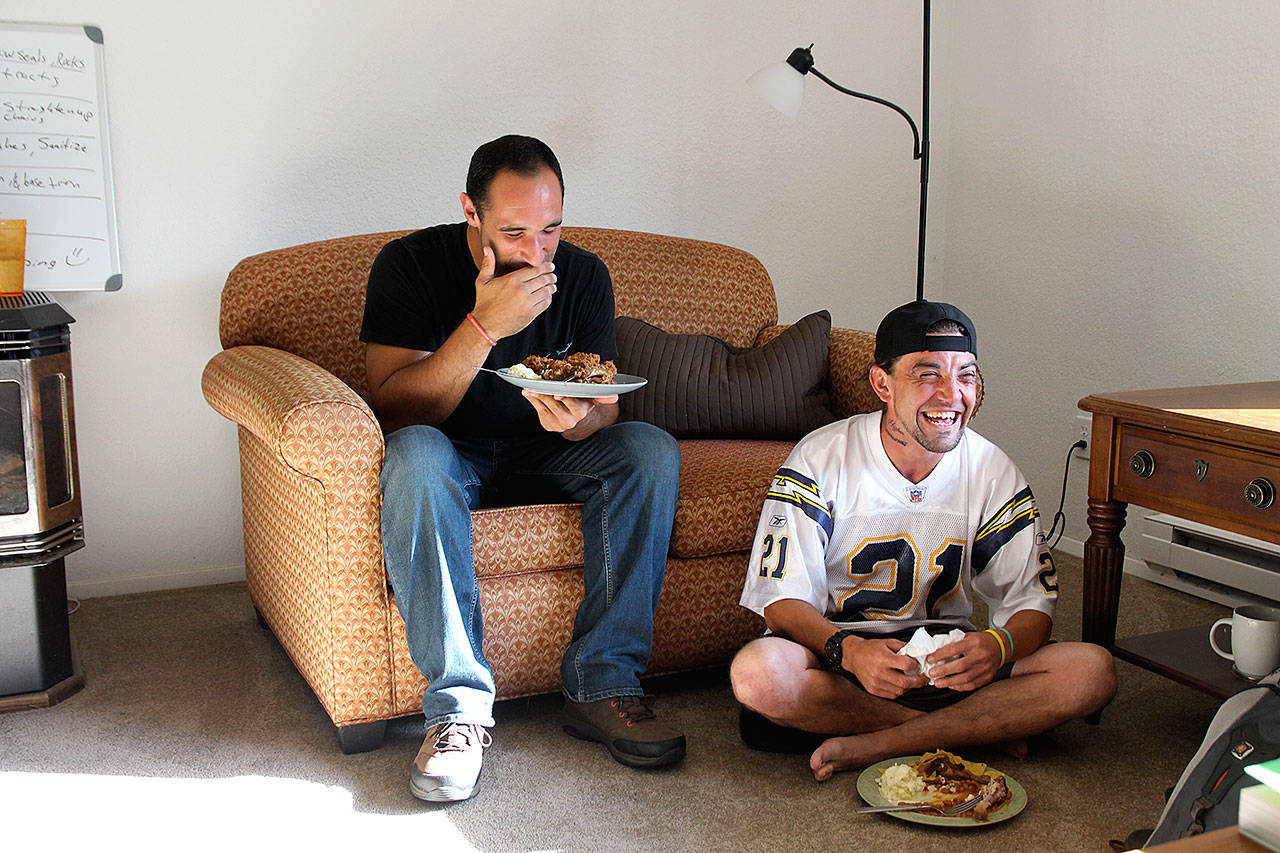Michael Steen, left, and Ryan Berry crack up during a house meeting Monday at Jake’s House, a sober home run by a local nonprofit. Photo by Laura Guido/Whidbey News-Times