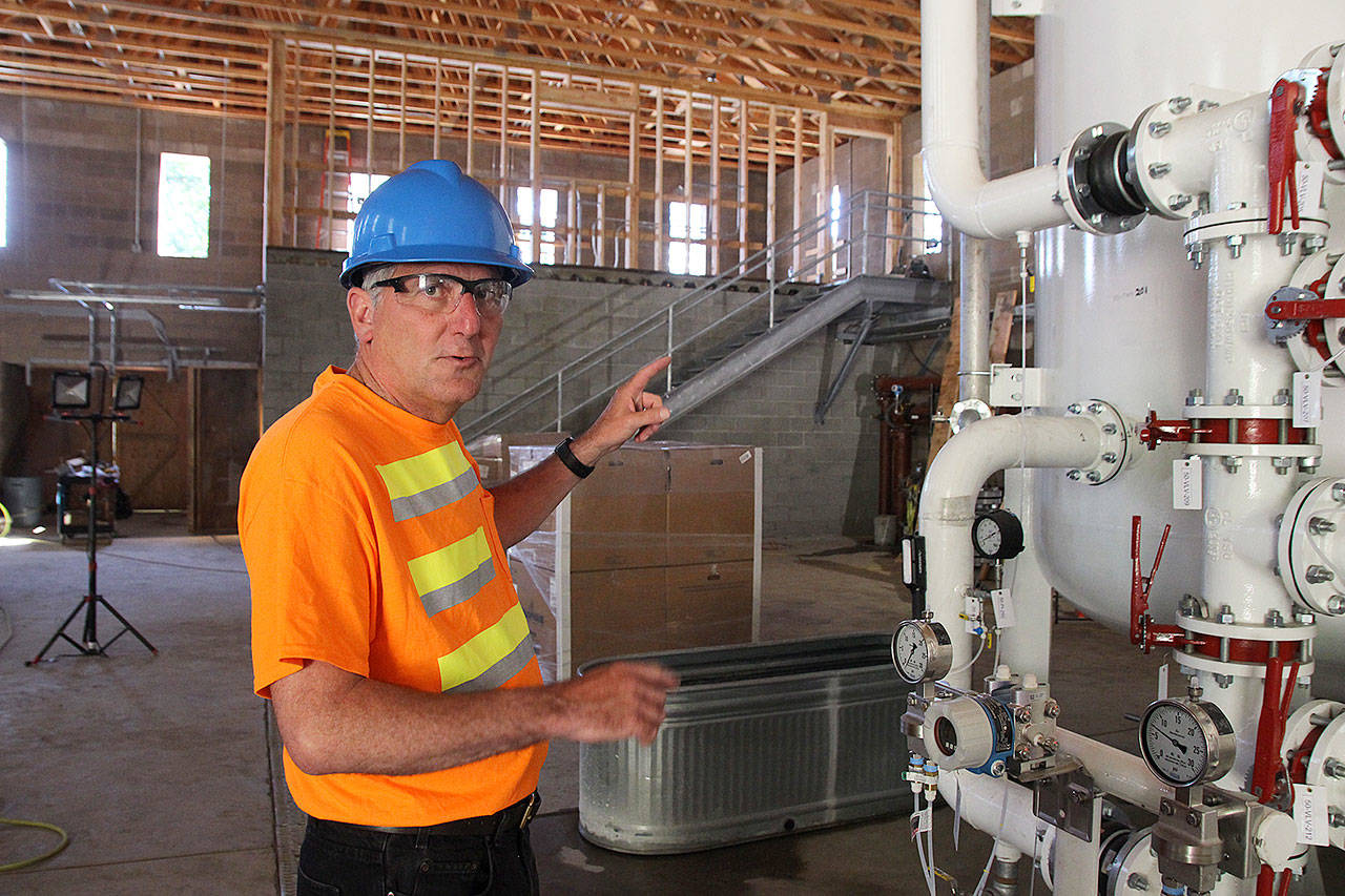 Utility Superintendent Joe Grogan explains how the new granular activated carbon filtration system works. It has been filtering Coupeville’s water for about a week. Photo by Laura Guido/Whidbey News-Times