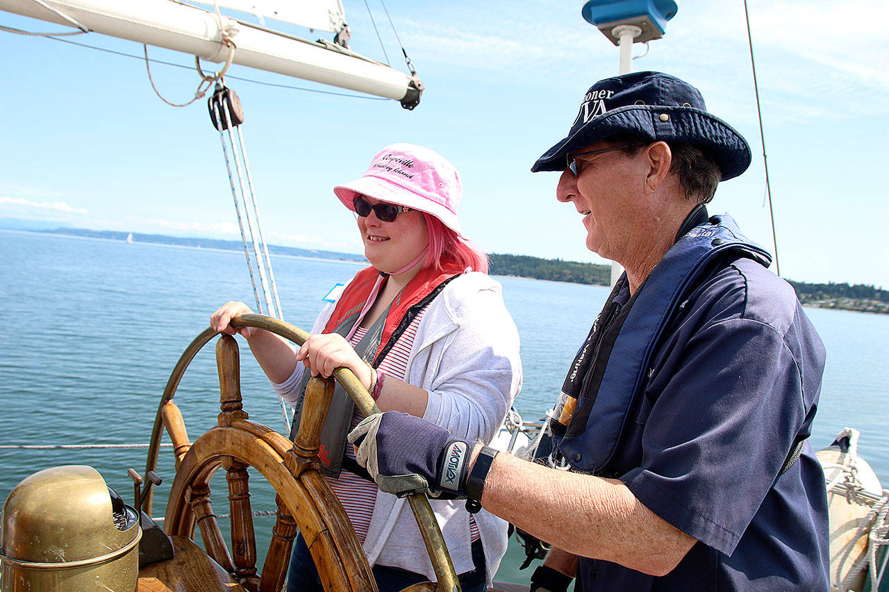 Photo by Laura Guido/Whidbey News-Times                                Dagne Shellenberg a member of Heritage Adventurers, steers the schooner Suva Wednesday under the direction of Capt. Gary McIntyre during a special sailing for the local nonprofit group.