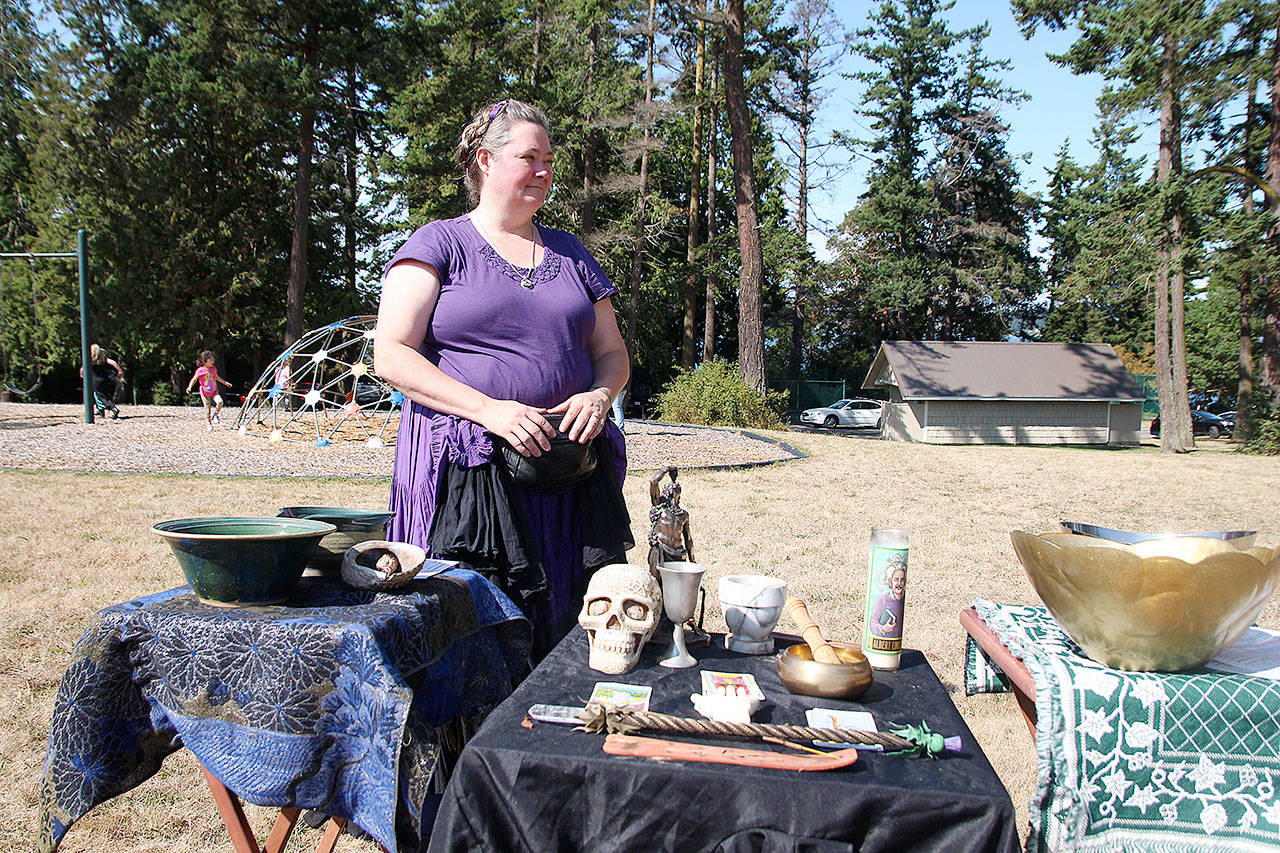 Tabitha Pierzchala stands near an altar, provided by Pagan Pride, at the first annual Whidbey Island Pagan Pride Festival Saturday at Town Park.