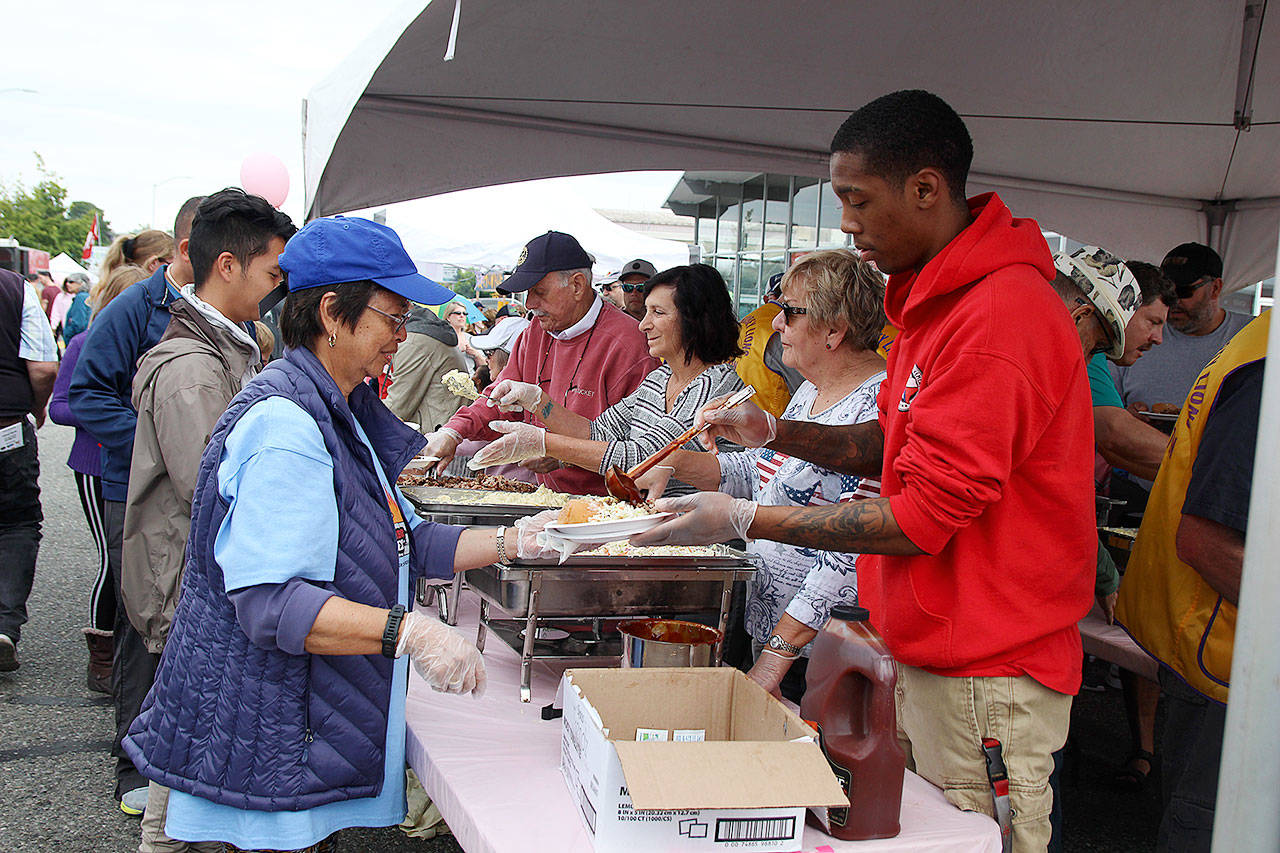Volunteers serve up a free lunch at Pigfest Sunday in Oak Harbor.