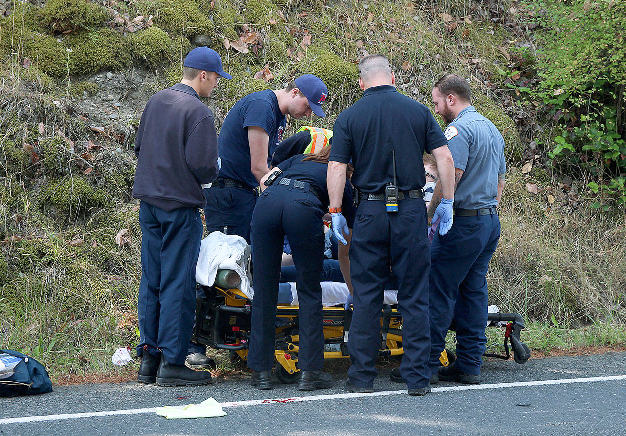 Photo by Laura Guido/Whidbey News-Times                                First responders secure a woman on a stretcher after a motorcycle accident Wednesday on Libbey Road.