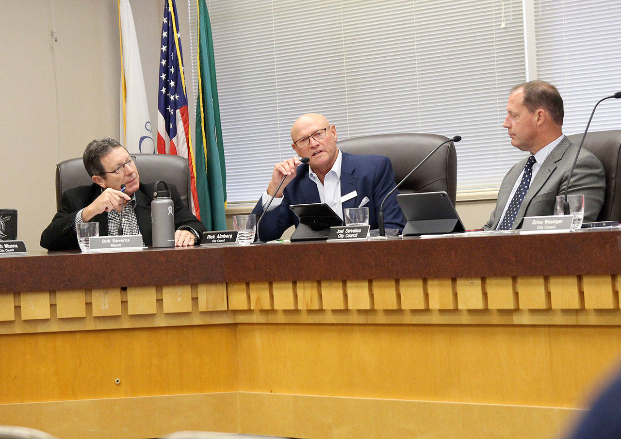 Councilman Rick Almberg, center, speaks during Tuesday’s Oak Harbor City Council meeting as Mayor Bob Severns, right, and Councilman Joel Servatius listen. The council approved permits for a controversial downtown development. Photo by Laura Guido/Whidbey News-Times