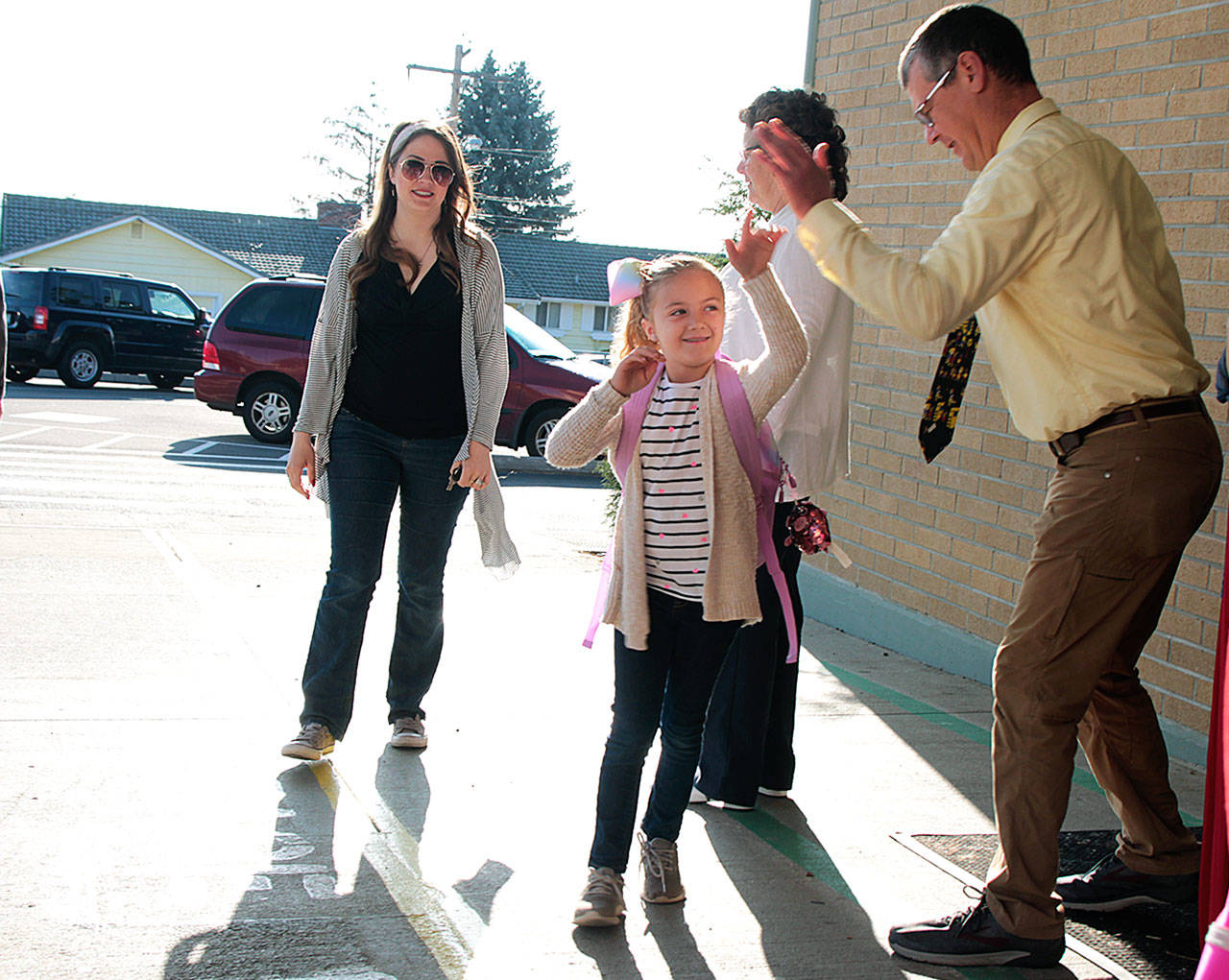 Olivia King high fives teacher Philip Southwick on her first day of second grade Thursday at Broad View Elementary School in Oak Harbor. Buses were back on the road this week, with the school year starting in both Oak Harbor and Coupeville. Photo by Laura Guido/Whidbey News-Times