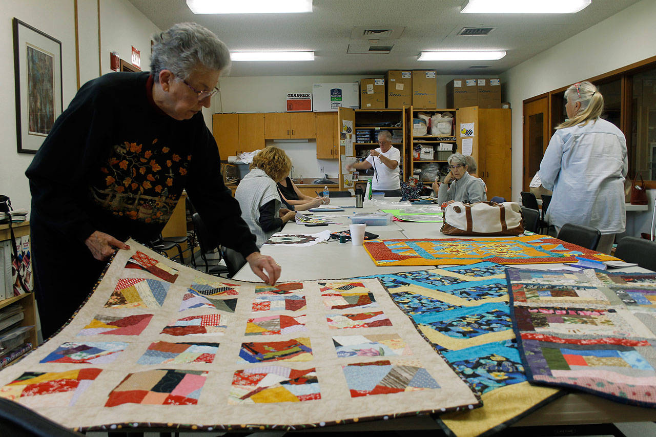 Flo Payeur arranges quilts at the Senior Bees morning meetup. (Photos by Maria Matson/Whidbey News-Times)