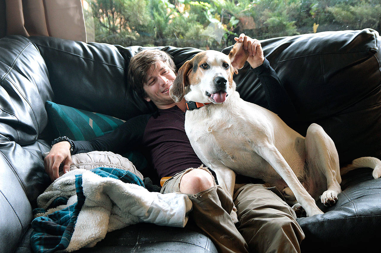 Photo by Laura Guido/Whidbey News-Times                                Spencer Tlougan, 23, cuddles with the resident canine Loki at Ryans House for Youth in Coupeville.