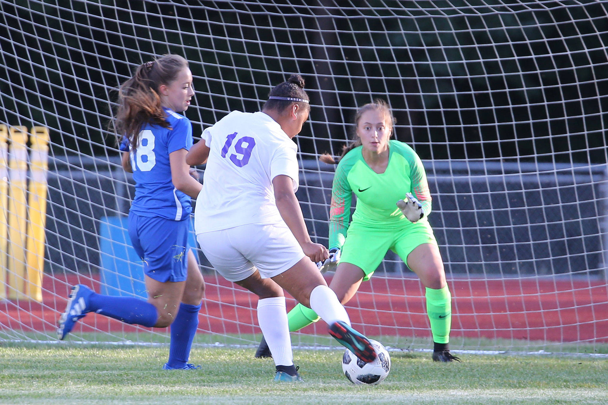 Oak Harbors Tiana Jacksons shoots by the defense of South Whidbeys Ashton Helseth (18) and Nicole Helseth. (Photo by John Fisken)