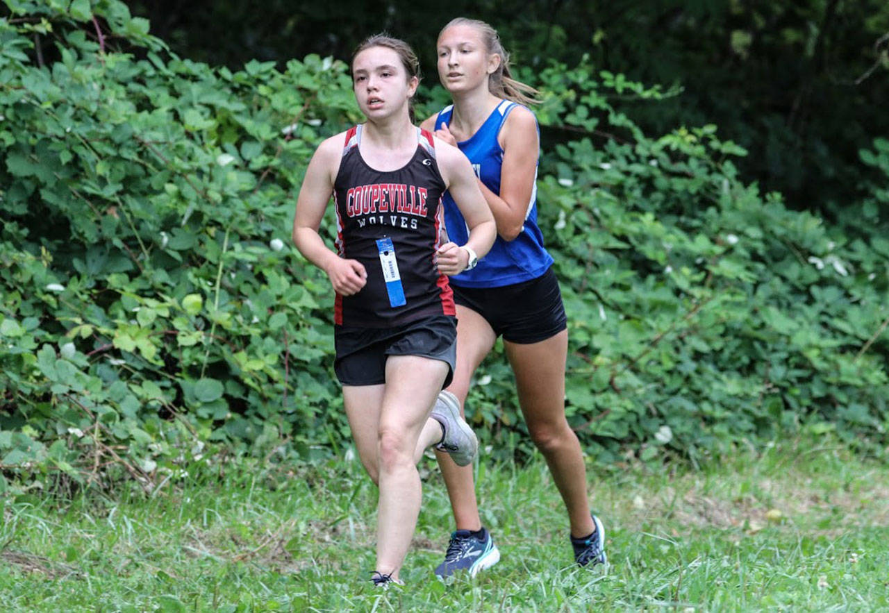 Coupeville’s Alana Mihill runs ahead of South Whidbey’s Laila Gmerek Thursday. (Photo by Matt Simms)