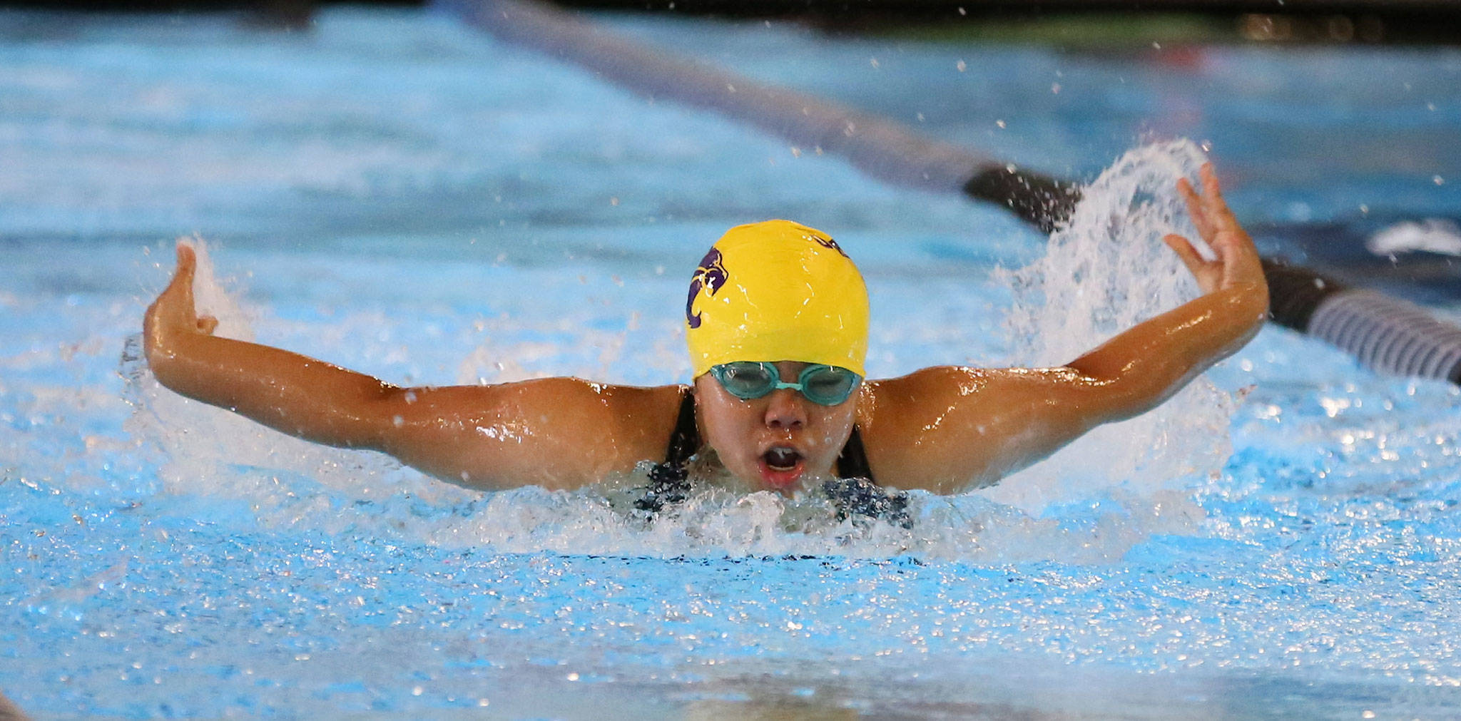 Oak Harbor’s Casey Cabigting competes in the 100-meter butterfly in Tuesday’s meet. (Photo by John Fisken)
