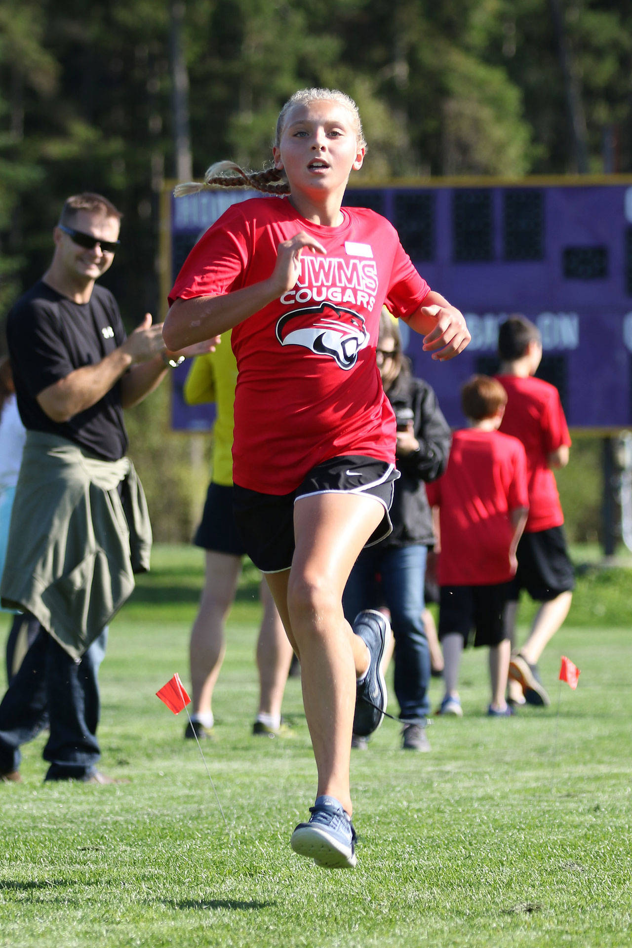 Addisen Boyers sprints to the finish line in first place in the seventh-grade girls race.(Photo by John Fisken)